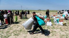 A displaced Iraqi receives humanitarian aid supplies at a camp for the internally displaced, in Salamiyah village east of Mosul, on March 27, 2017