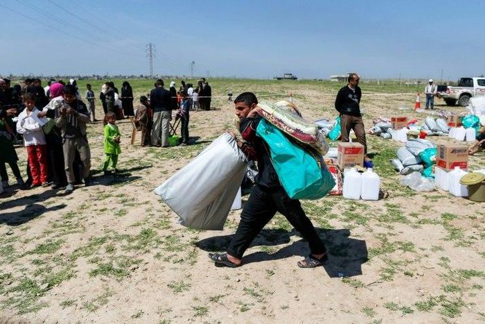 A displaced Iraqi receives humanitarian aid supplies at a camp for the internally displaced, in Salamiyah village east of Mosul, on March 27, 2017