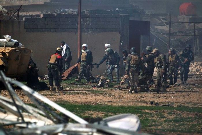 Iraqi security forces evacuate comrades wounded in an explosives-laden vehicle attack claimed by Islamic State group south of Mosul