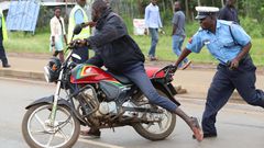 A police officer arresting a boda boda rider