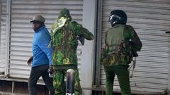 Police officers confront city hawker in Nairobi during protests