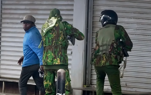 Police officers confront city hawker in Nairobi during protests