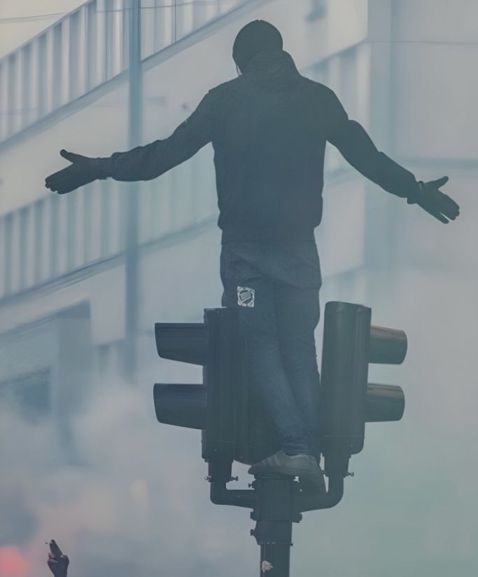 A protester standing on top of a traffic light pole during the anti-Finance Bill protests in Nairobi Central Business District on June 18, 2024.