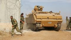 Pro-Turkish Syrian fighters drive an armoured personnel carrier across the border into Syria as they take part in an offensive against Kurdish-controlled areas in northeastern Syria launched by the Turkish military, on October 11, 2019