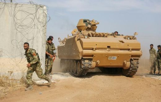 Pro-Turkish Syrian fighters drive an armoured personnel carrier across the border into Syria as they take part in an offensive against Kurdish-controlled areas in northeastern Syria launched by the Turkish military, on October 11, 2019