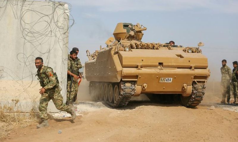Pro-Turkish Syrian fighters drive an armoured personnel carrier across the border into Syria as they take part in an offensive against Kurdish-controlled areas in northeastern Syria launched by the Turkish military, on October 11, 2019