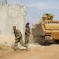 Pro-Turkish Syrian fighters drive an armoured personnel carrier across the border into Syria as they take part in an offensive against Kurdish-controlled areas in northeastern Syria launched by the Turkish military, on October 11, 2019