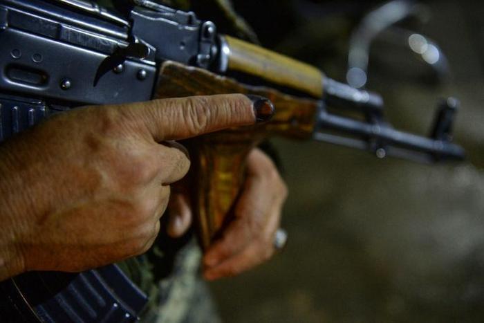 A security guard shows his finger marked with ink as he holds a weapon after casting his vote in Afghanistan's presidential elections. Initial data suggests turnout at a record low