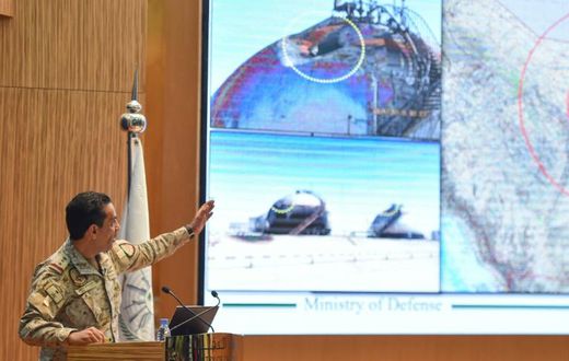 Saudi defence ministry spokesman Turki bin Saleh al-Malki shows off pictures as he alleges that strikes on the country's oil infrastructure came from the north and were 'unquestionably' sponsored by Iran