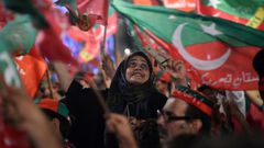 Pakistan Tehreek-e-Insaf supporters wave party flags during campaigning that brought Imran Khan to power in July 2018