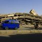A van drives by a building flattened in Saudi-led coalition air strikes in Amran, 50 kilometres (30 miles) north of the Yemeni capital Sanaa