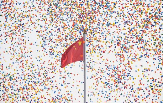 Balloons fly past a national flag at the end of the military parade in Tiananmen Square