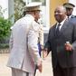 Bongo, centre, shakes hands at a ceremony to honour Gabon's first president