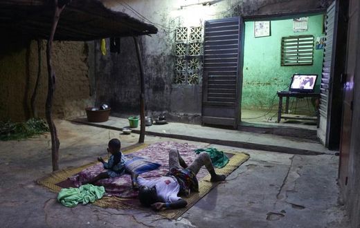 Two displaced children lie down to watch television in Segou. Authorities hope to get them into school alongside local boys and girls
