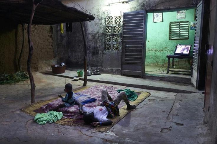 Two displaced children lie down to watch television in Segou. Authorities hope to get them into school alongside local boys and girls