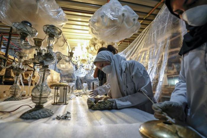 Labourers clean chandeliers during the restoration of Mohamed Ali Shubra Palace in the Egyptian capital Cairo