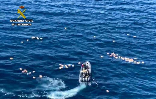 This handout picture released by the Spanish Guardia Civil shows a speedboat surrounded by bundles of drugs in the sea, after a police high-speed chase with drug-smugglers, off the coast of Mijas, Malaga, southern Spain