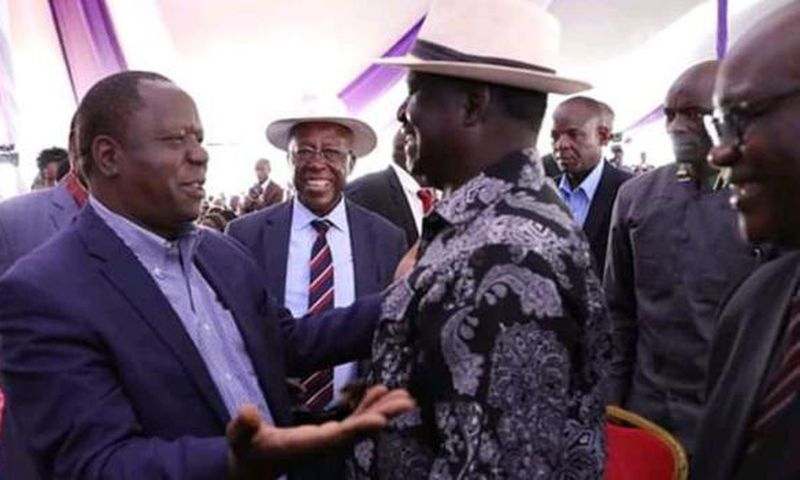 Raila Odinga with Fred Matiangi at the burial of Hezron Manduku
