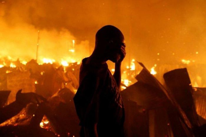 A man sobs during past attempts to put out a fire in one of Kenya's Nairobi slums (Twitter)