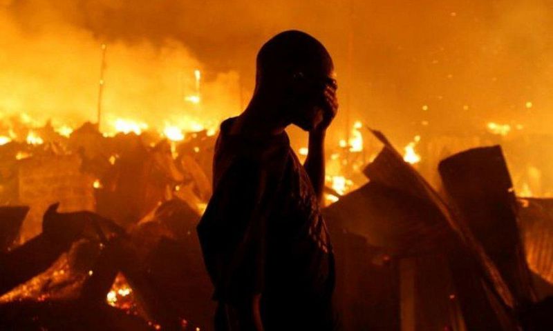 A man sobs during past attempts to put out a fire in one of Kenya's Nairobi slums (Twitter)