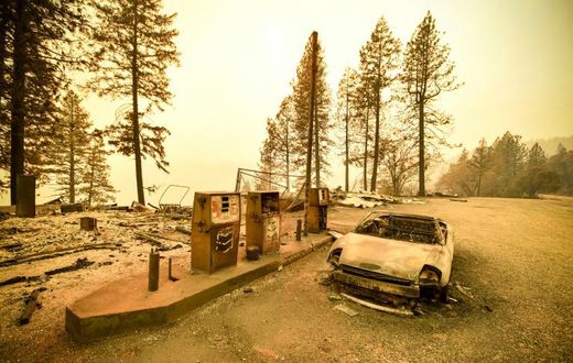 A burnt car and a gas station remain visible on November 11, 2018 after the "Camp" fire tore through the region near Pulga, east of Paradise, California