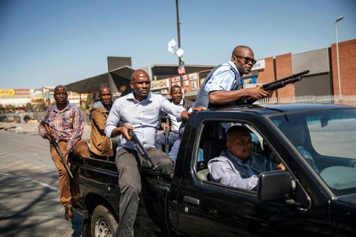 Plainclothes police patrol the Johannesburg township of Alexandra after the unrest