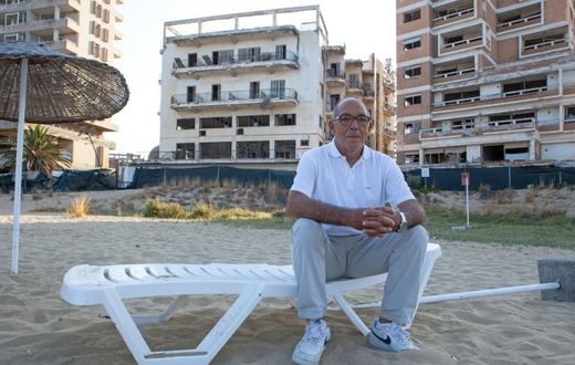 Pavlos Iacovou sits near the ghost town of Varosha, fenced off by occupying Turkish soldiers in 1974