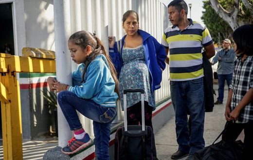 Migrants from Honduras wait in line at the Mexico-United States border crossing in Tijuana, Mexico on September 12, 2019