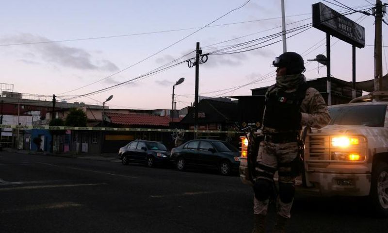 Mexican soldiers guard a crime scene where a man was killed by gunfire in downtown Tijuana, one of many cities riven by drug cartel violence in the country