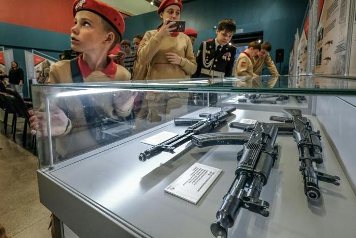 Members of Russia's Young Army patriotic movement get a close-up look at Russia's iconic Kalashnikov at a Moscow exhibition dedicated to their inventor