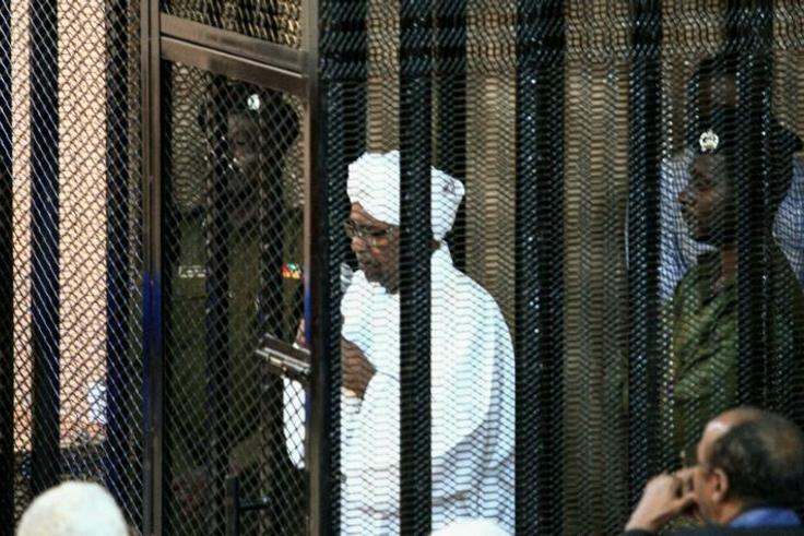 Sudan's ex-president Omar al-Bashir (C) appears in court in the capital Khartoum to face charges of illegal acquisition and use of foreign funds