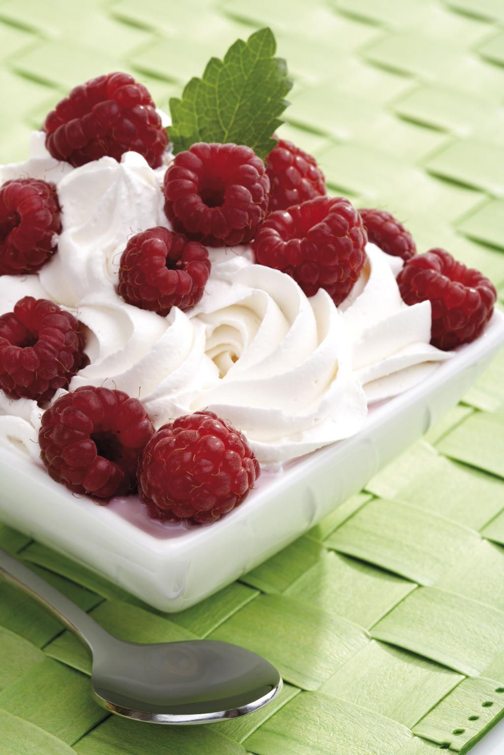 "Rasberries on whipped cream in bowl, close-up"