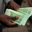 A man holds "bond notes" equivalent to US dollars released by the Reserve Bank of Zimbabwe to ease critical cash shortages