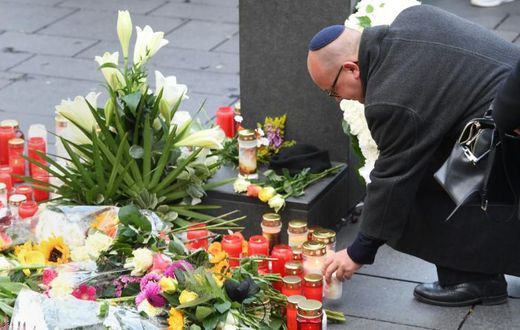 A man wearing a kippah skullcap places a candle at a makeshift memorial a day after two people were shot dead as Halle's Jewish community marked Yom Kippur