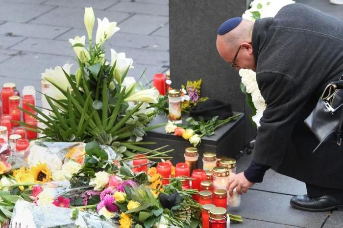 A man wearing a kippah skullcap places a candle at a makeshift memorial a day after two people were shot dead as Halle's Jewish community marked Yom Kippur