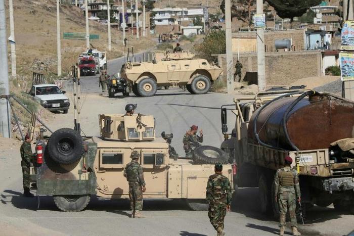 Afghan National Army soldiers stand guard and inspect the site of a suicide car bomb attack by the Taliban in Char Asiab district, south of Kabul, on September 12