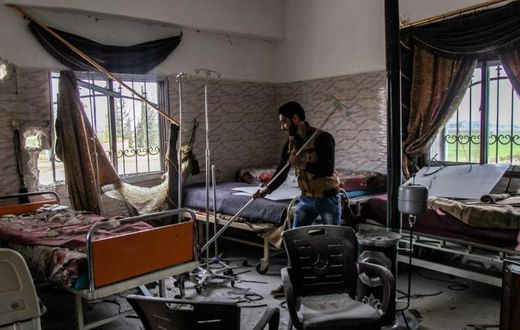 A Syrian man clears rubble in a hospital that was hit by an alleged regime air strike in the town of Saraqib, northern Idlib province, on March 10, 2019