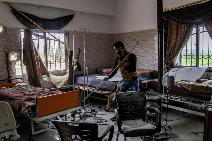 A Syrian man clears rubble in a hospital that was hit by an alleged regime air strike in the town of Saraqib, northern Idlib province, on March 10, 2019
