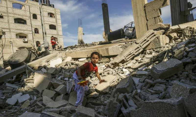 A Palestinian girl climbs on the remains of a building destroyed during an Israeli air strike on Rafah in the southern Gaza Strip on May 5, 2019