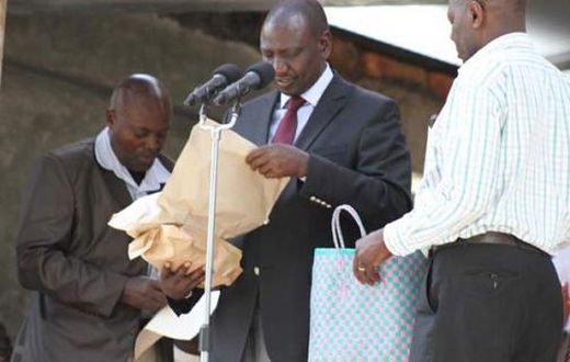 File image of DP Ruto holding cash donations at a past harambee