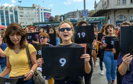 Women held signs with different numbers signifying some of the victims killed this year