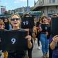 Women held signs with different numbers signifying some of the victims killed this year