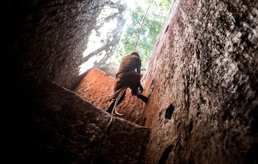 A subsistence miner in Mabakulu, eastern DR Congo, clambers out of a mine shaft with the help of a vine. Safety in Congo's illegal mining sector is poor, and accidents are frequent (file picture)