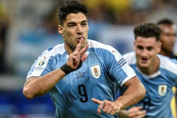 Luis Suarez wheels away in celebration after netting Uruguay's third goal following a flick-on by Martin Caceres