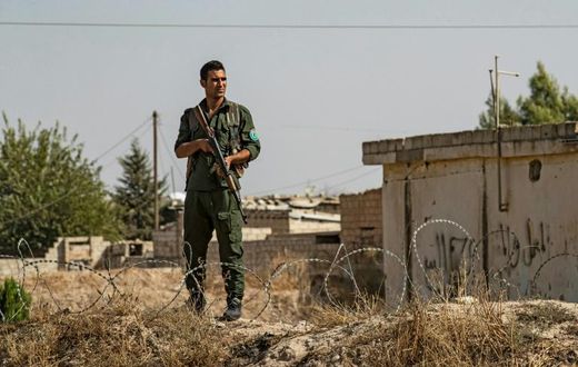 Kurdish security forces stand guard during a demonstration by Syrian Kurds against Turkish threats of a military operation in northern Syria
