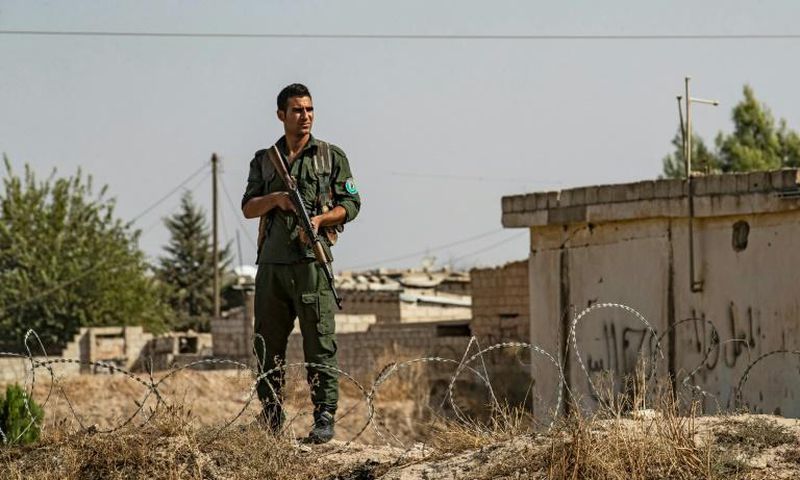 Kurdish security forces stand guard during a demonstration by Syrian Kurds against Turkish threats of a military operation in northern Syria