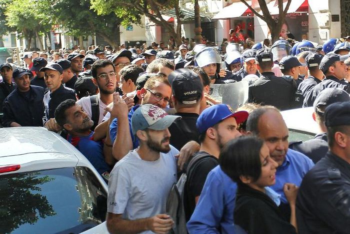 Algerian police officers confront protesters during an anti-government demonstration in the capital Algiers