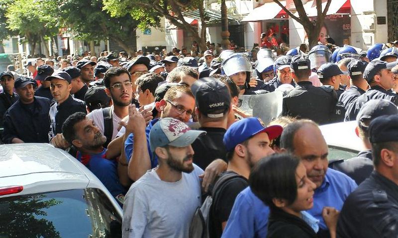 Algerian police officers confront protesters during an anti-government demonstration in the capital Algiers