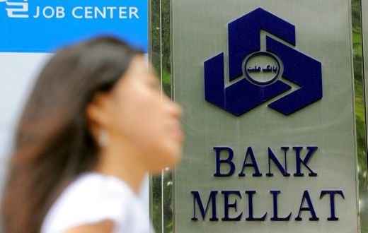 Iran has claimed a "victory" after one of its banks received compensation from British authorities over "illegal" sanctions; in a file picture taken on September 8, 2010 a woman walks past a signboard of Bank Mellat, an Iranian state-run commercial ban...