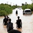 Sudanese people walk a flooded road in Wad Ramli village on the eastern banks of the Nile river